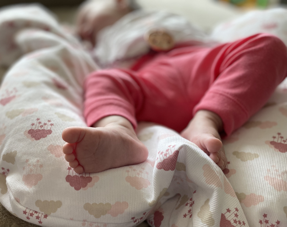 Petits pieds d'un nouveau-né sur un lange à motifs nuages